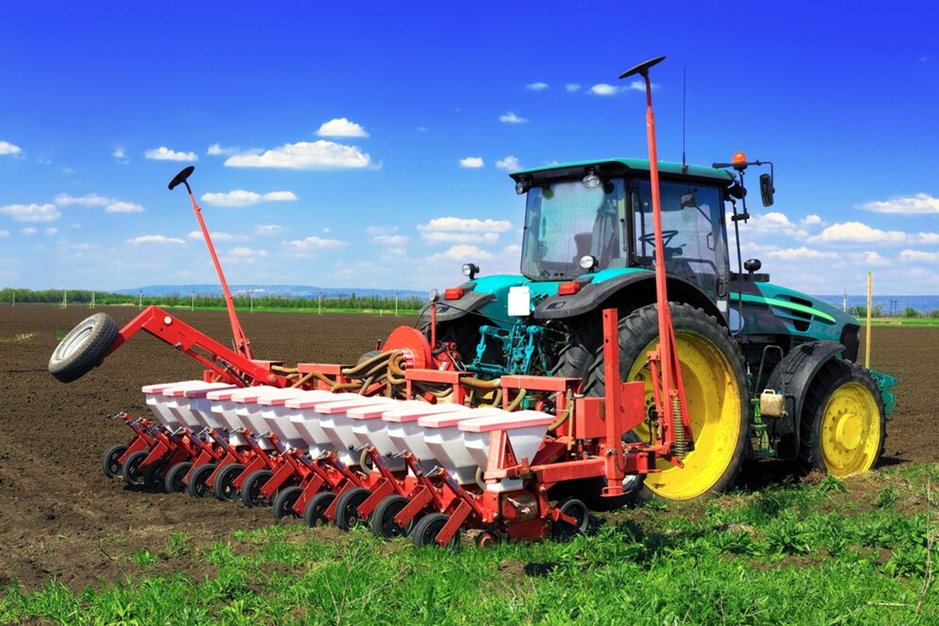 Un tracteur et un large outil derrière lui